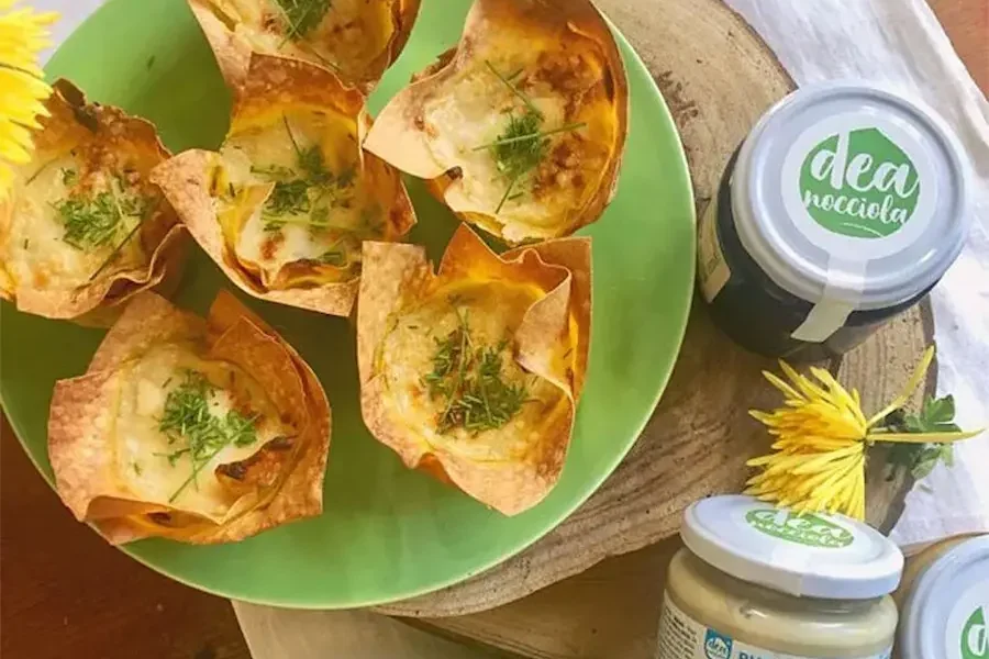 Mini lasagne con zucchine, pomodori secchi e besciamella in un piatto con crema di anacardo