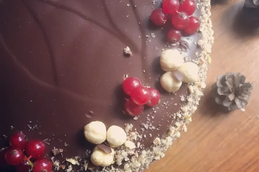 Mud cake con crema di nocciola decorata con ribes e nocciole