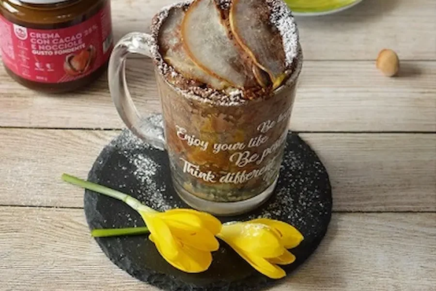 Mug cake con crema fondente dea nocciola e pere, sullo sfondo un vasetto di crema spalmabile Fondente