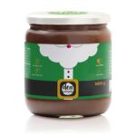 vasetto di crema al latte con etichetta natalizia con sfondo verde al centro barba di babbo natale e cintura con scritta deanocciola