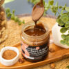 composizione con cucchiaino e crema tre ingredienti con nocciola, ciotolina con zucchero, nocciole sparse, su un vassoio di legno e tovaglietta di raffia
