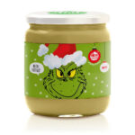 vasetto di crema al pistacchio e latte con etichetta natalizia con sfondo verde chiaro e stelline e al centro il viso del grinch con cappello di natale che dice buon natale