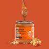 vasetto di crema di arachidi crunchy con una cucchiaita di crema e arachidi in frutto