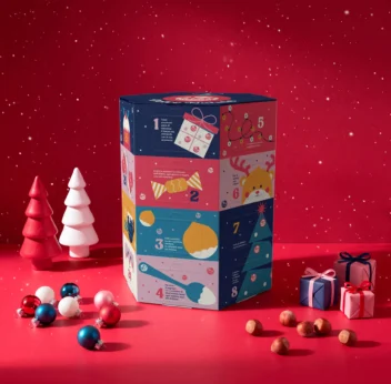 sfondo rosso, al centro calendario dell' avvento e decorazioni natalizie